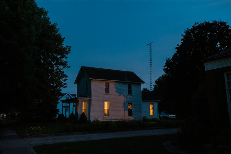 Dom jednorodzinny z oświetlonymi oknami nocą